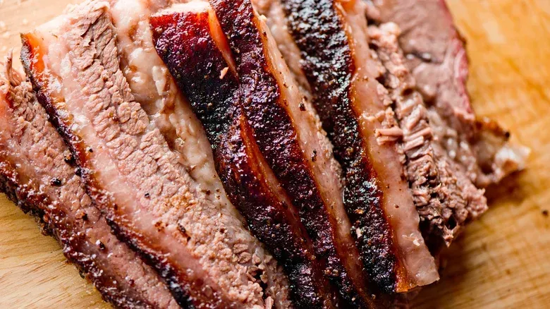 A close up of a piece of meat on a wooden cutting board.