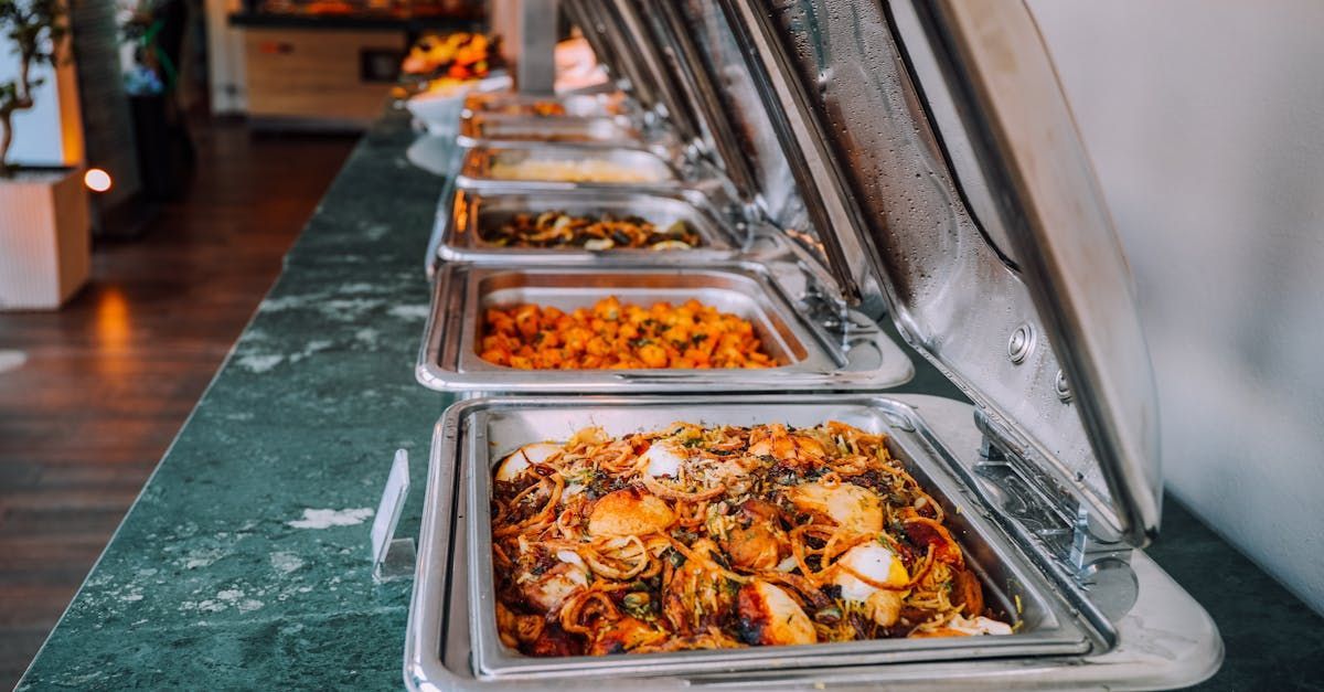 A row of buffet trays filled with food on a table.