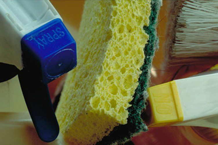 Sponge between two spray triggers from cleaning bottles
