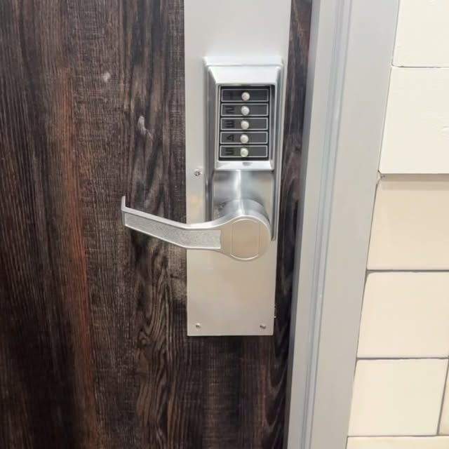 A close up of a door lock on a wooden door.