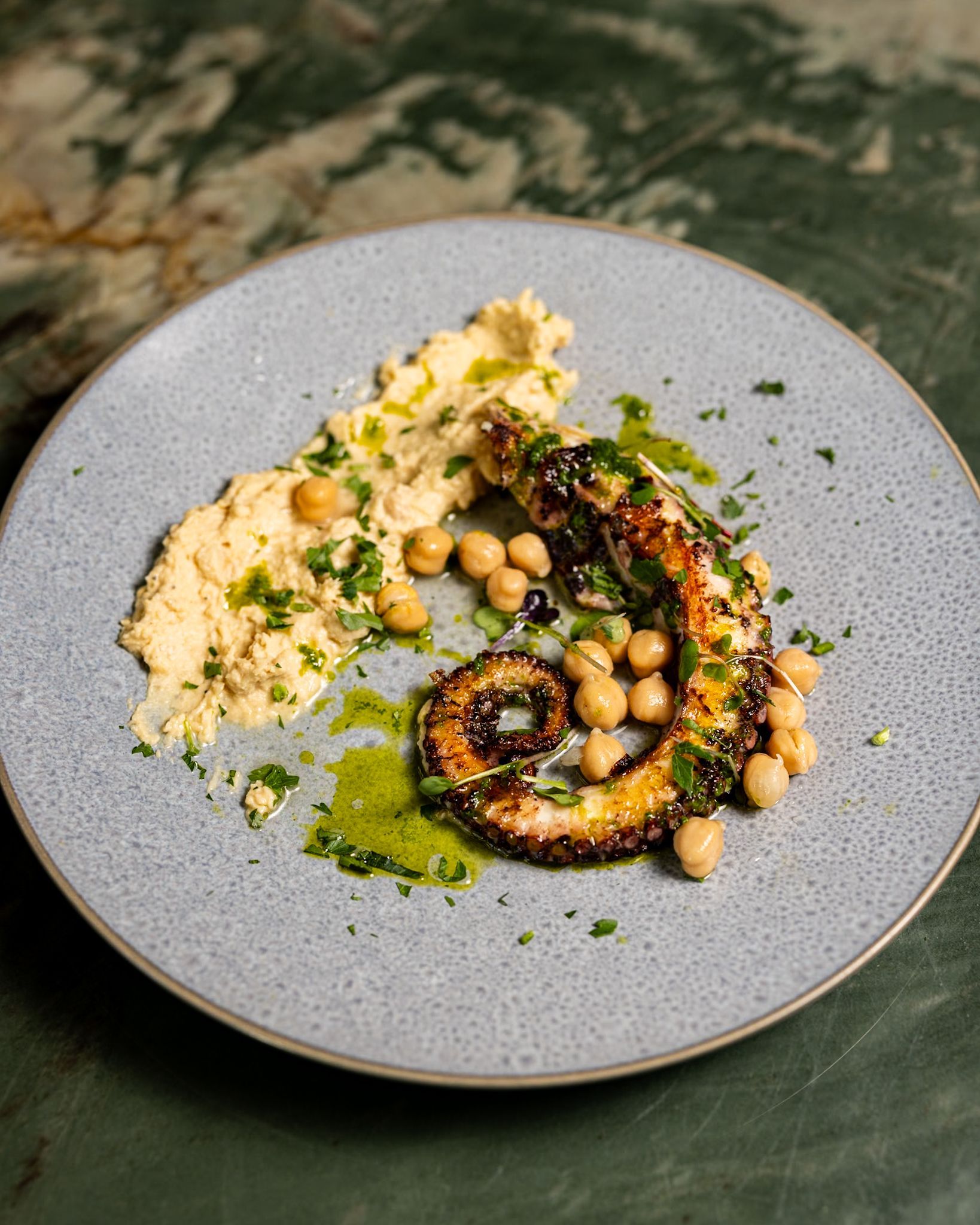 A plate of food with chickpeas and hummus on a table.