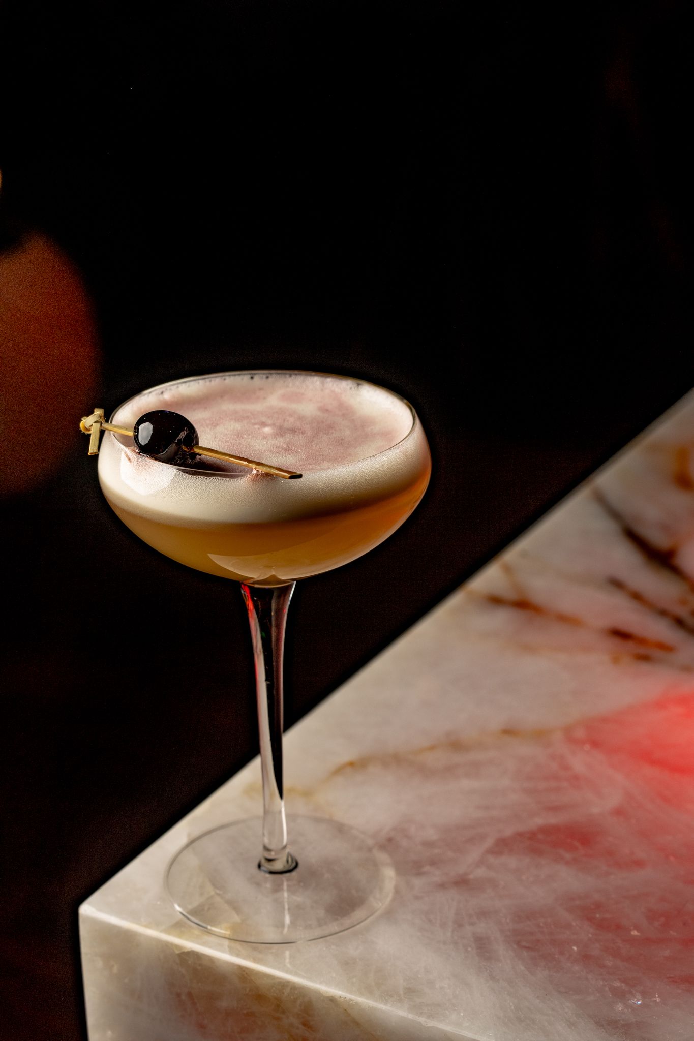 A close up of a cocktail in a martini glass on a table.