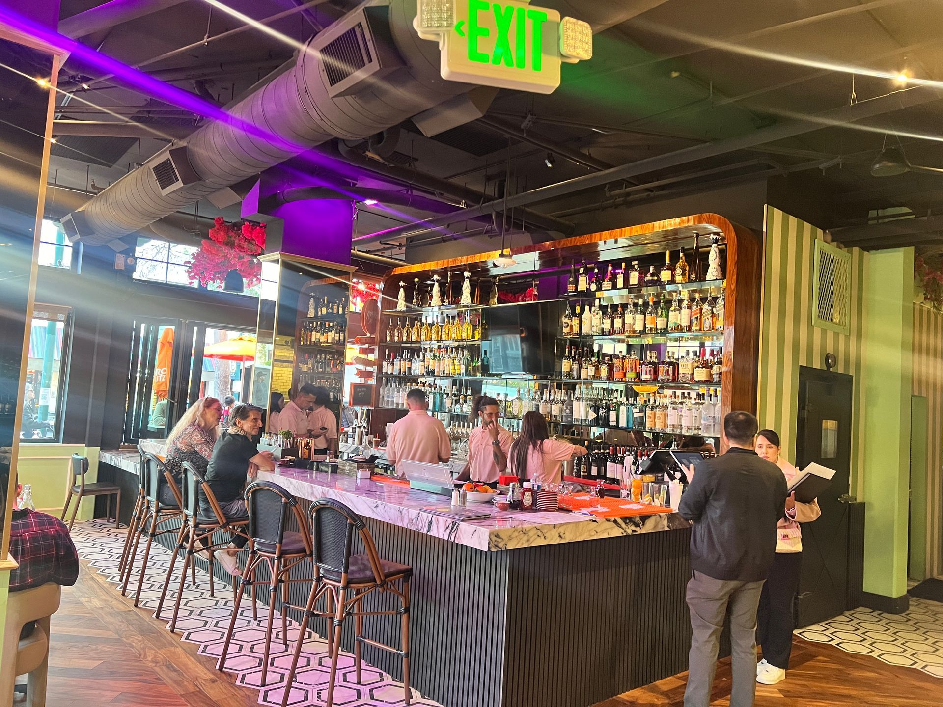 A group of people are sitting at a bar in a restaurant.
