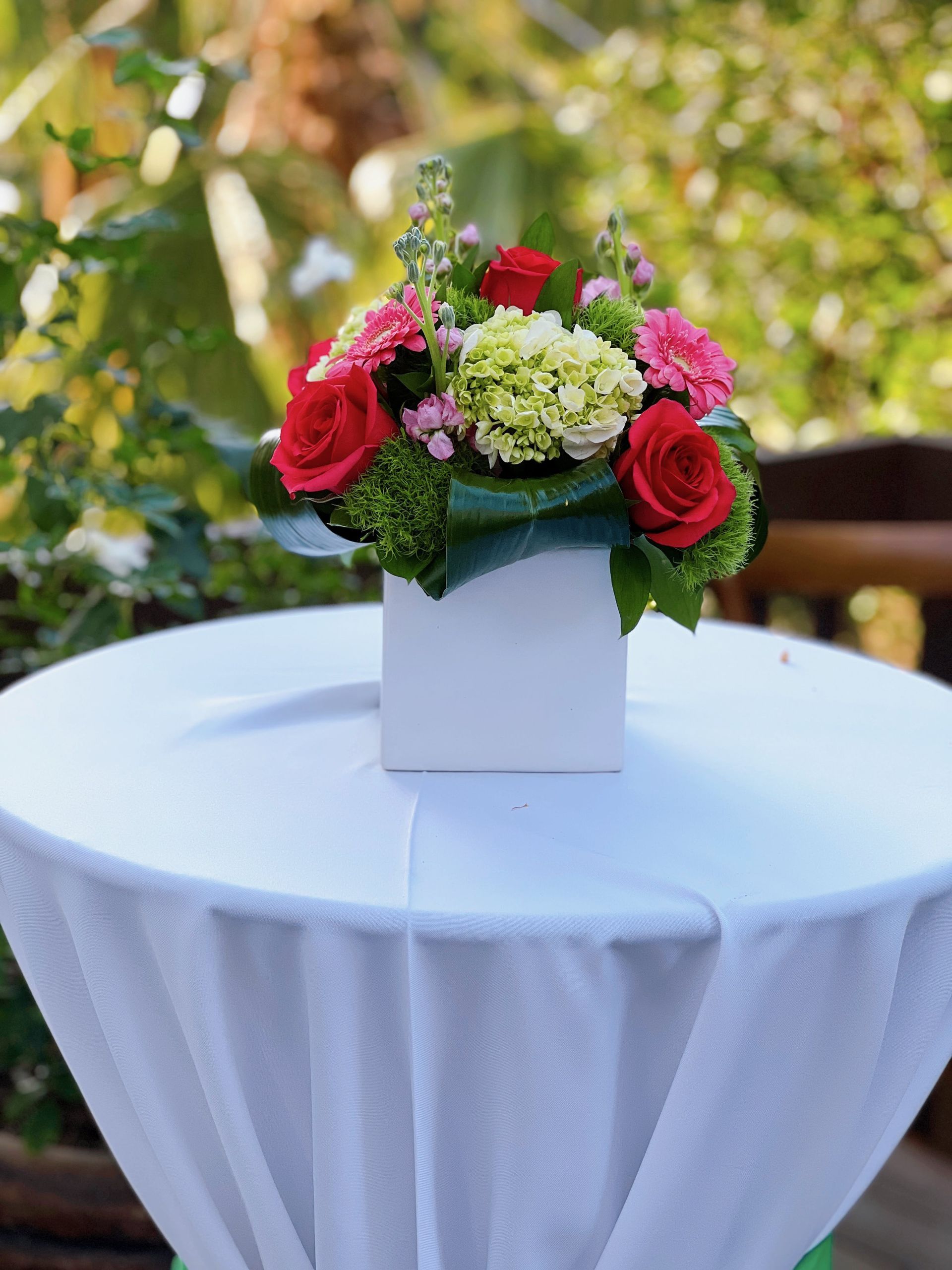 A white table with a vase of flowers on it.
