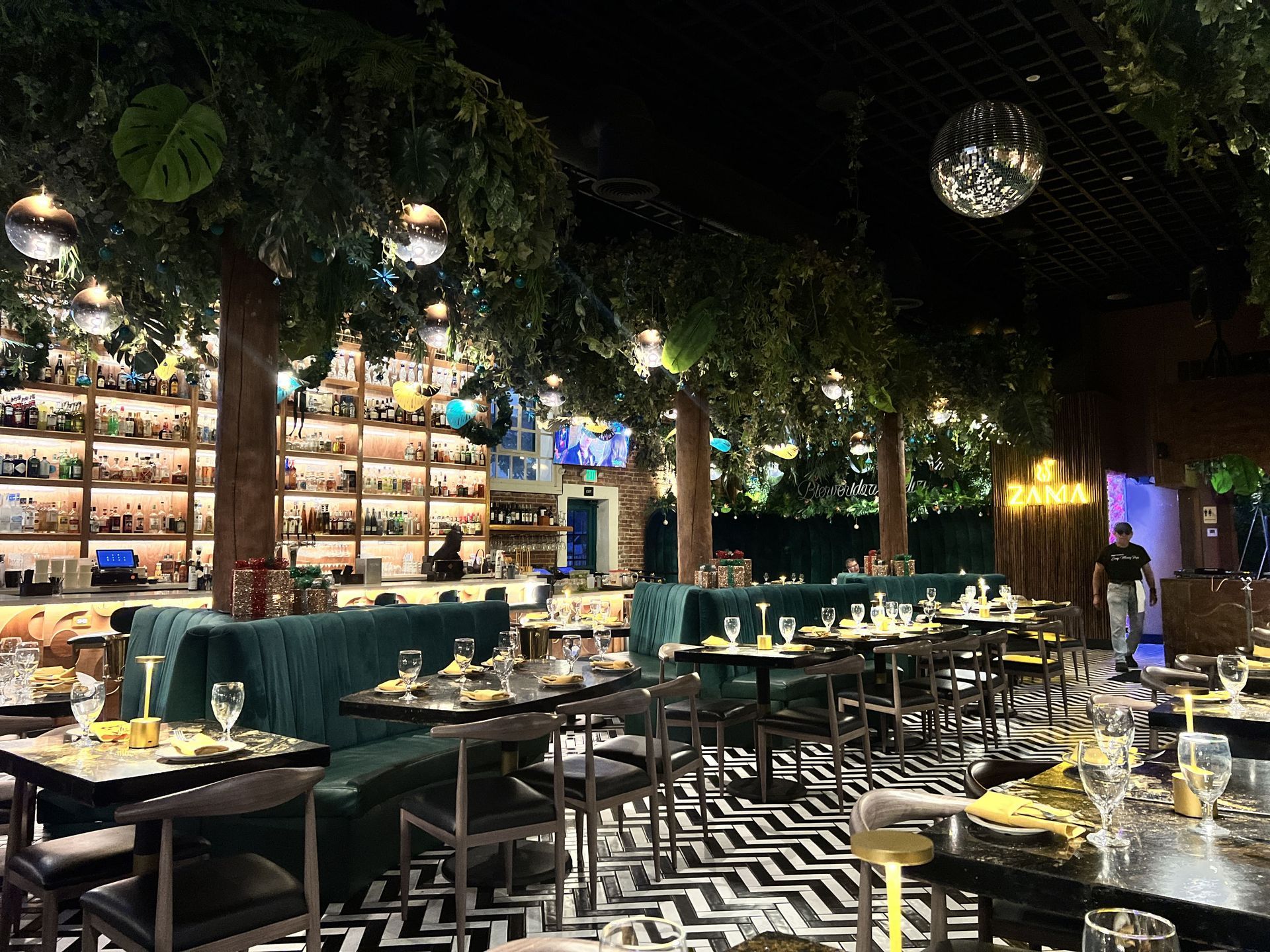 A restaurant filled with tables and chairs and a bar.