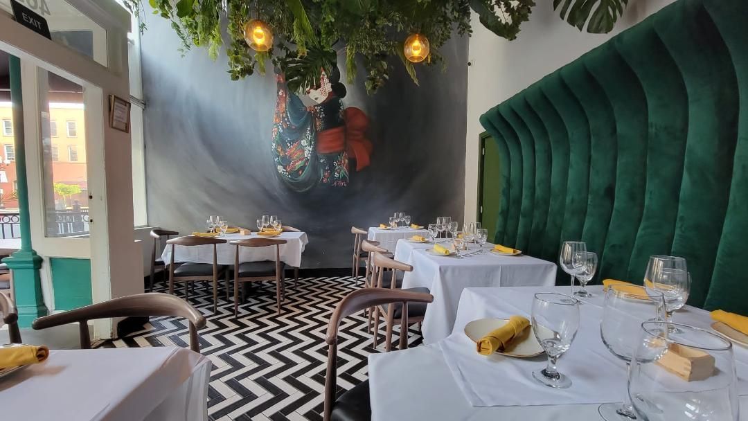 A restaurant with tables and chairs and a mural on the wall.