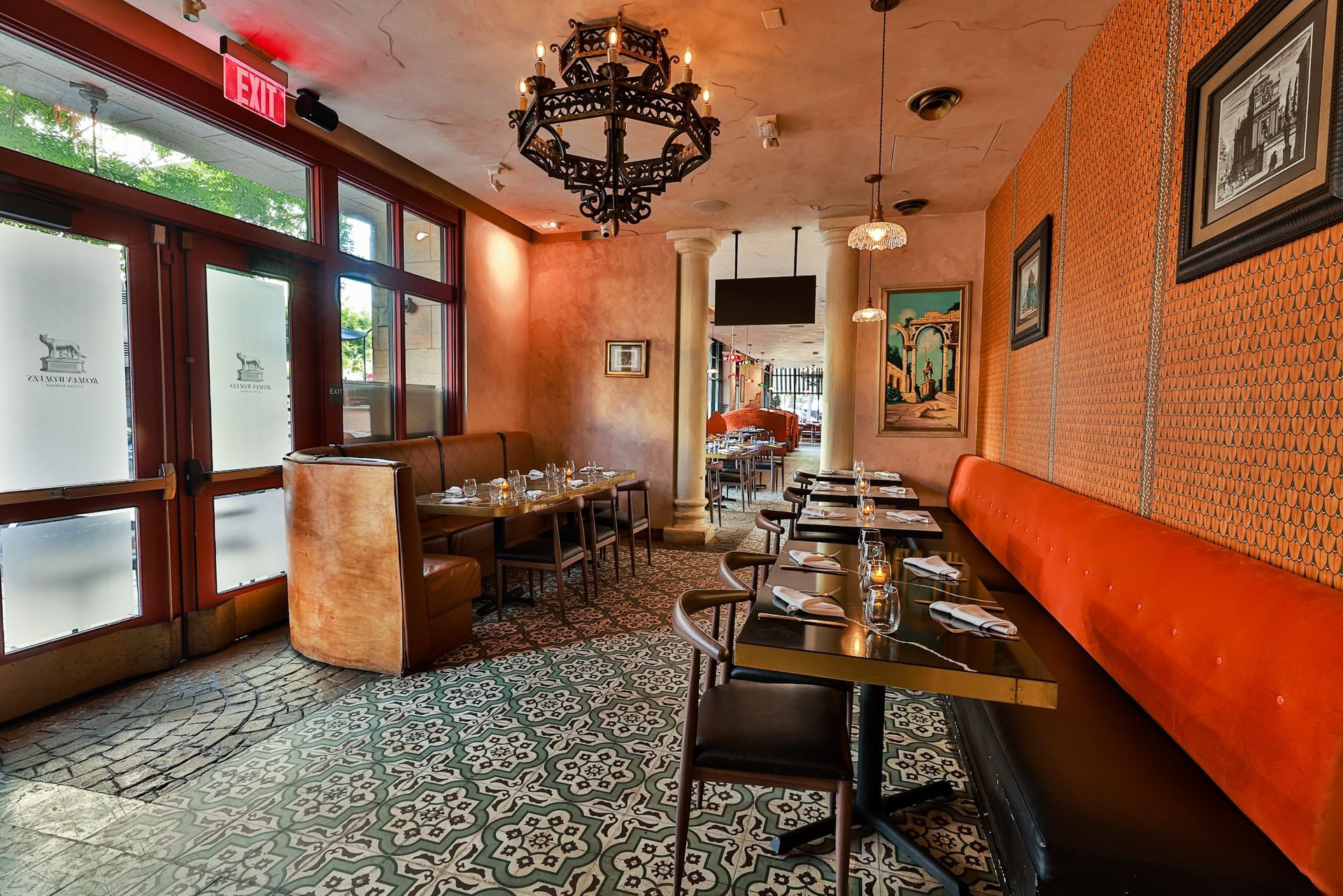 A restaurant with tables and chairs and a red exit sign