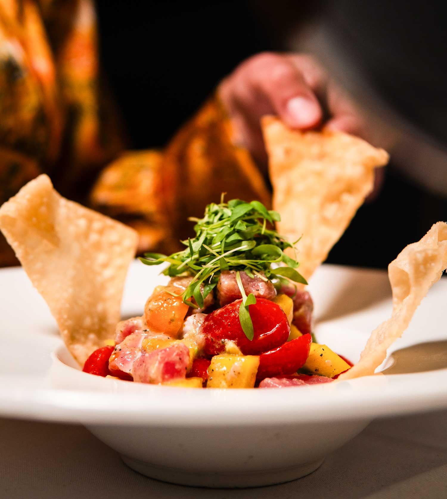 A close up of a bowl of food with tortilla chips on top