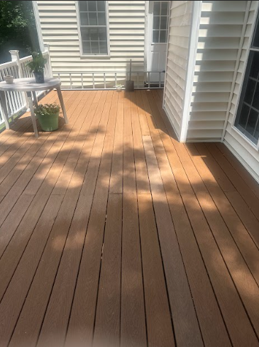 A wooden deck with a white house in the background