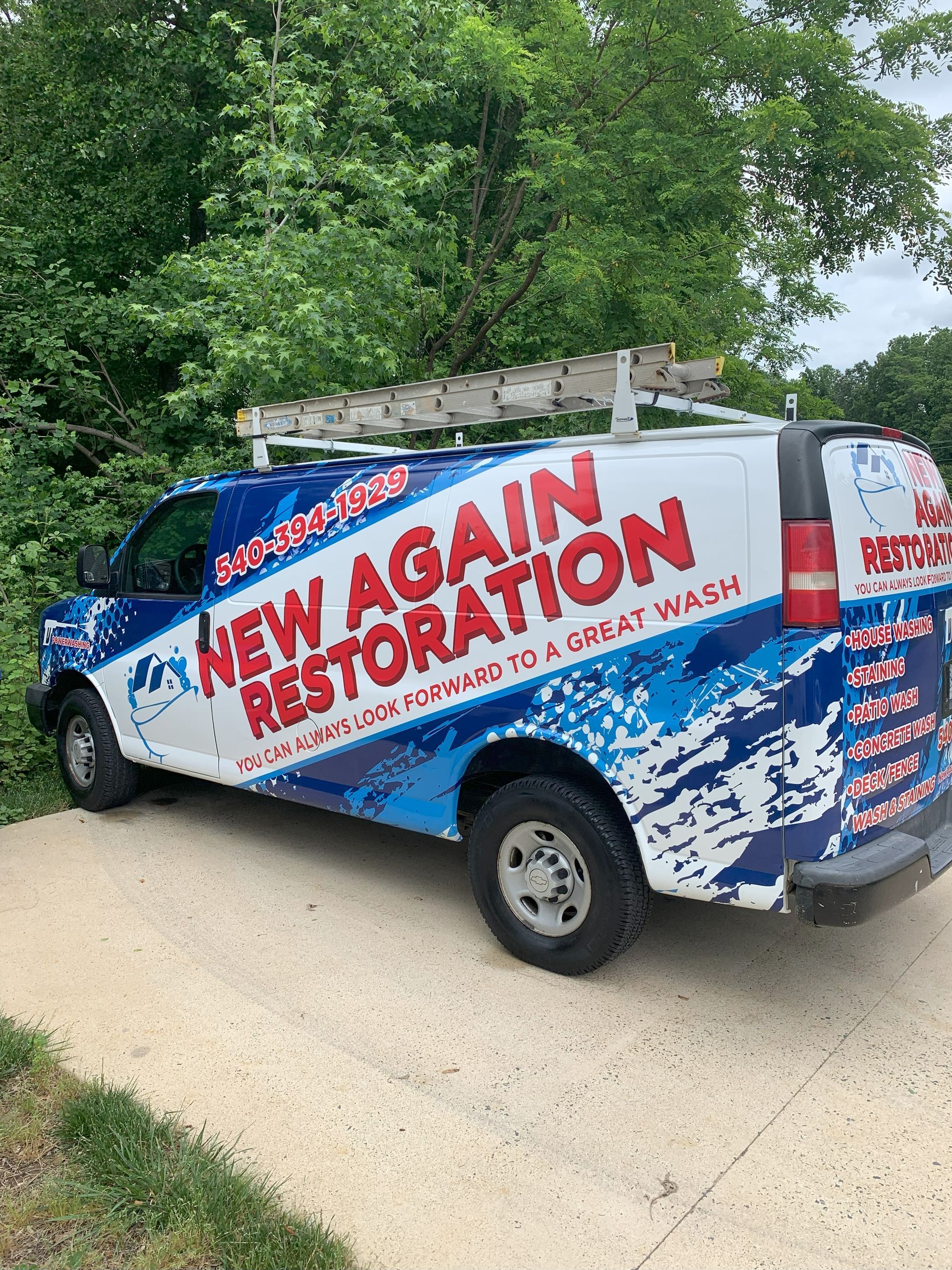 A new again restoration van is parked on the side of a road.