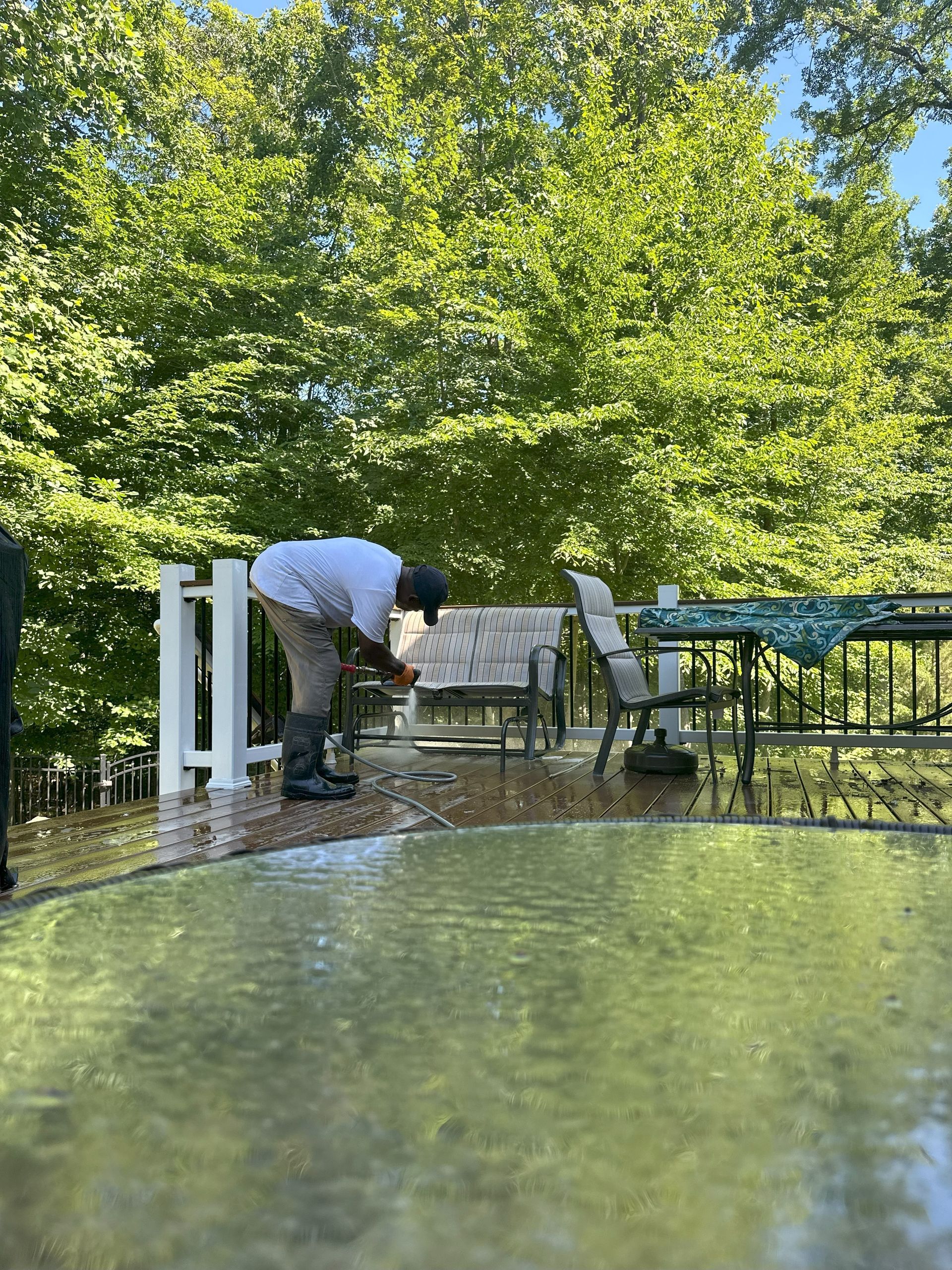 A man is cleaning a patio with a pressure washer.