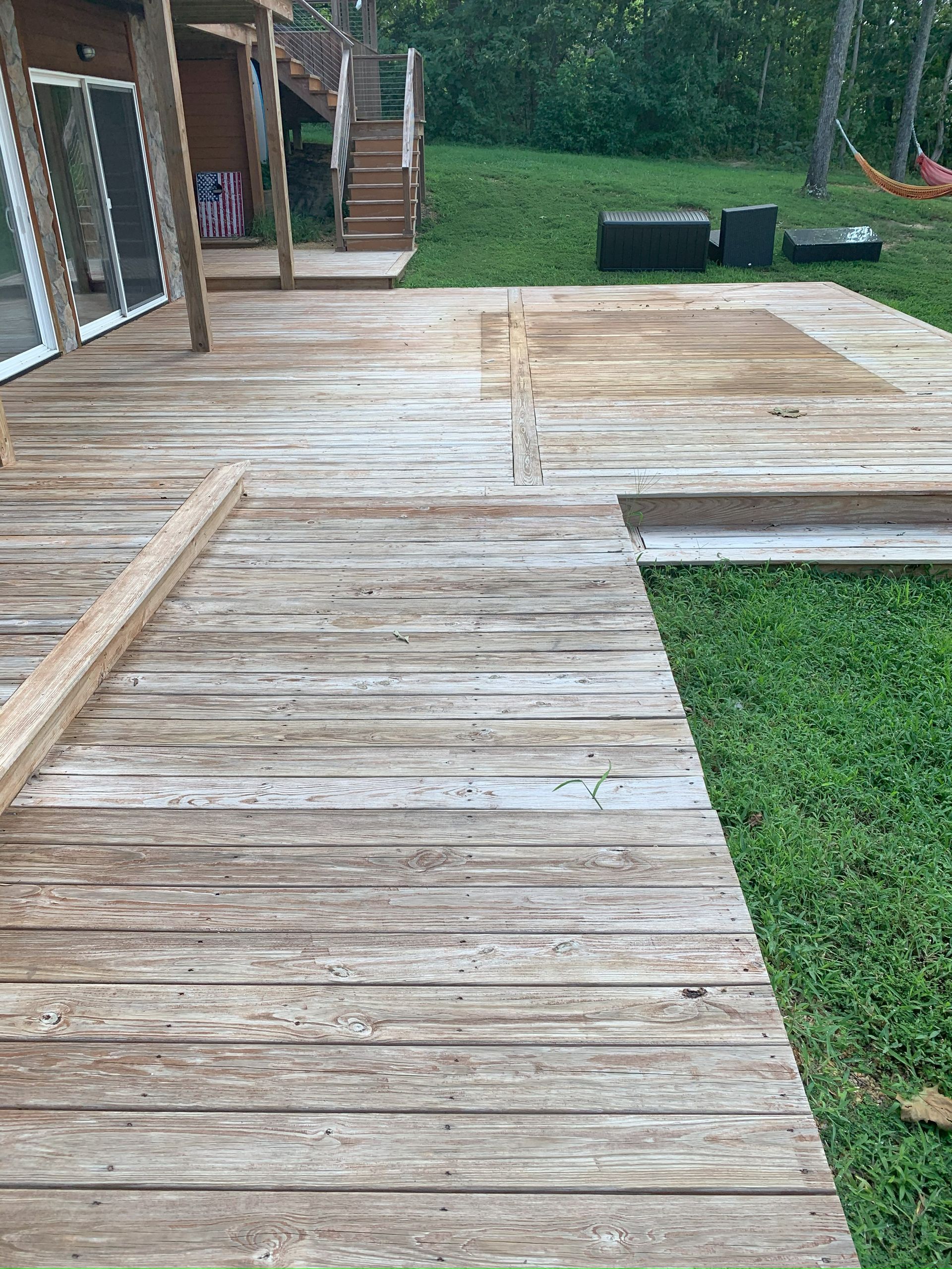 A wooden deck is sitting in the middle of a lush green field.
