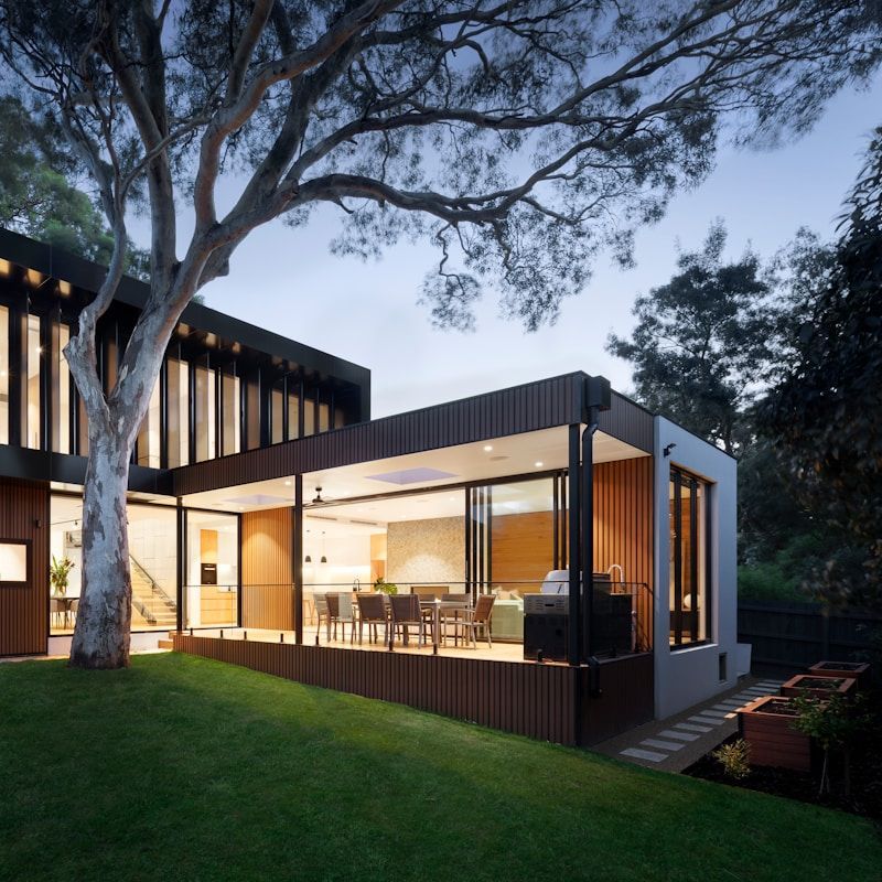 A house with a lot of windows and a tree in front of it