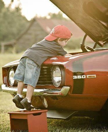 bambino incuriosito dal motore di un auto