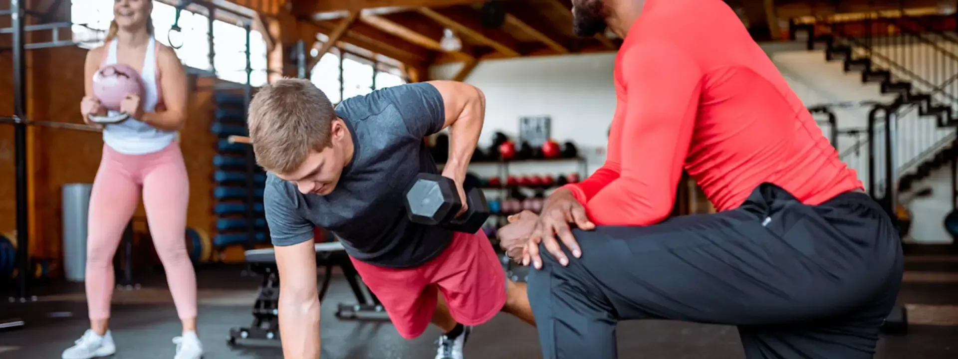 A woman is pulling a sled with weights in a gym.