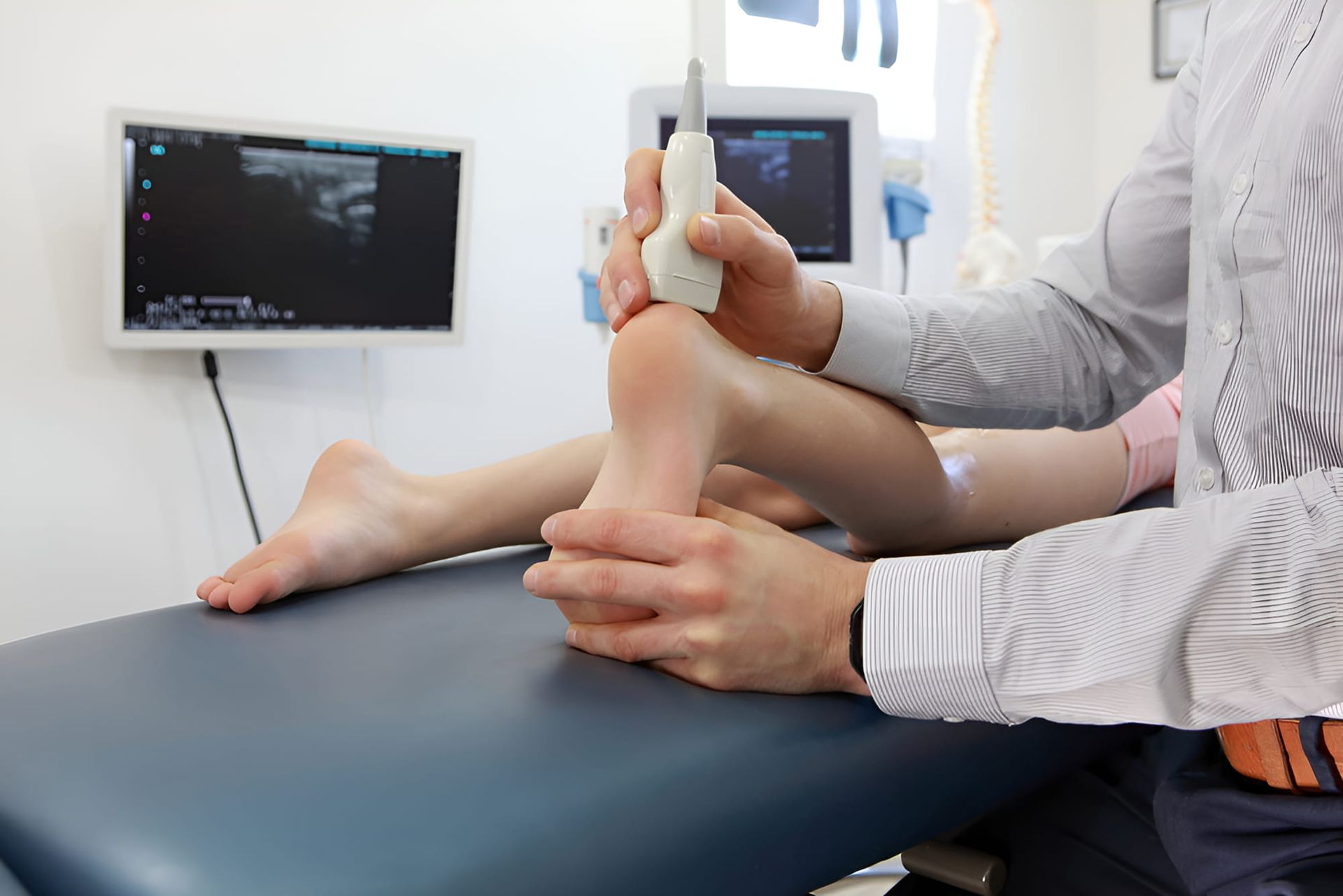 A Doctor Is Examining A Child's Foot With An Ultrasound Machine — Hastings Podiatry Centre In Port Macquarie, NSW
