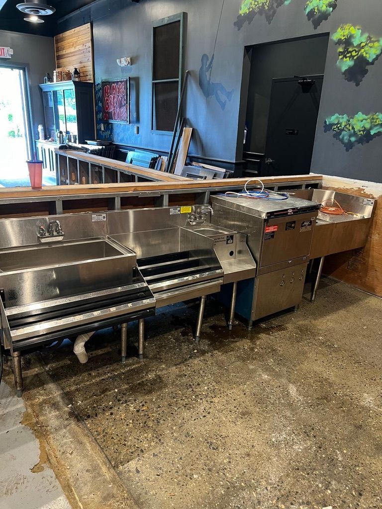 A Person Holding Three Faucets in front of a Tiled Wall - Passaic, NJ - Motion Plumbing & Heating LLC