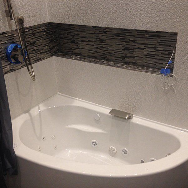 A Bathtub in a Bathroom with a Shower Head - Passaic, NJ - Motion Plumbing & Heating LLC