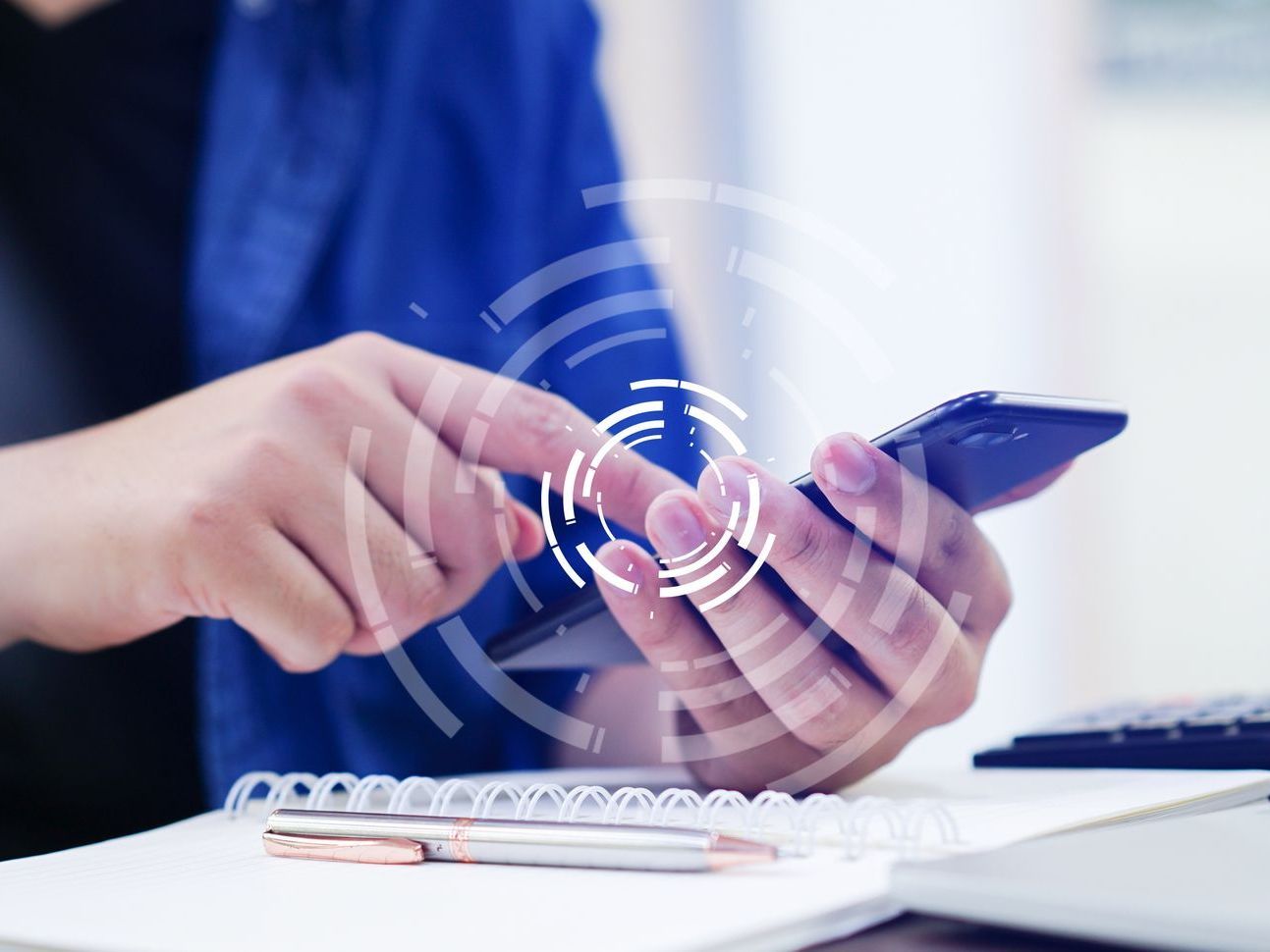 Closeup photo of a person at a desk checking their phone with an artistic overlay representing social media.