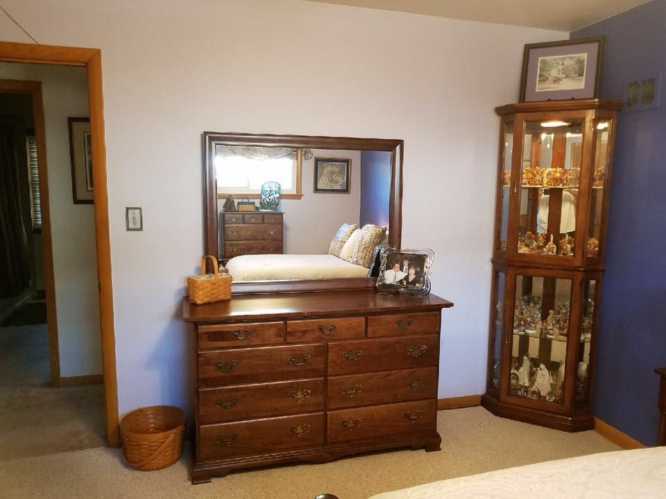 A bedroom with a dresser and a mirror