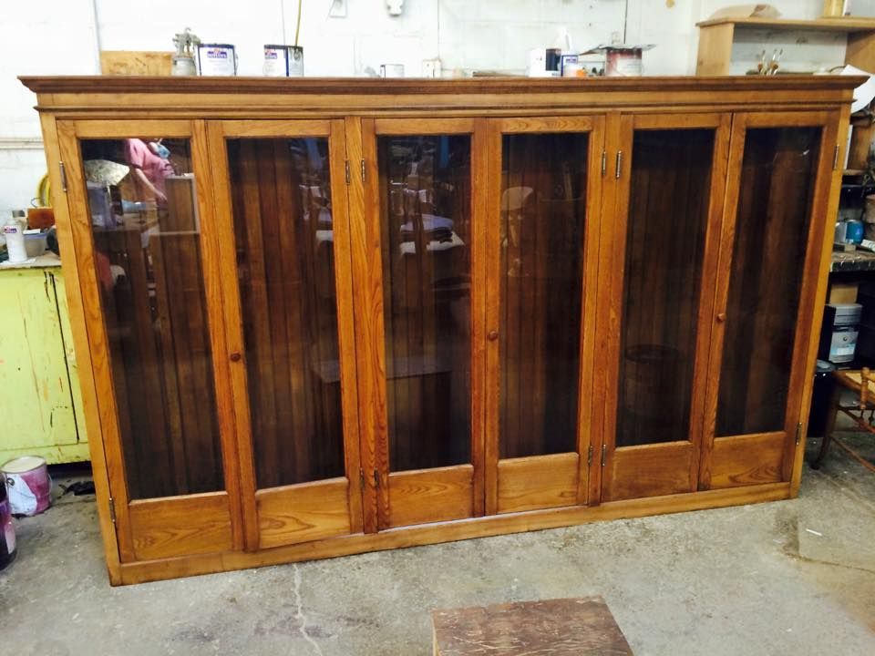 A large wooden cabinet with glass doors in a room