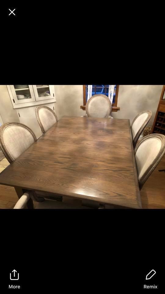 A dining room table and chairs in a room with a window.