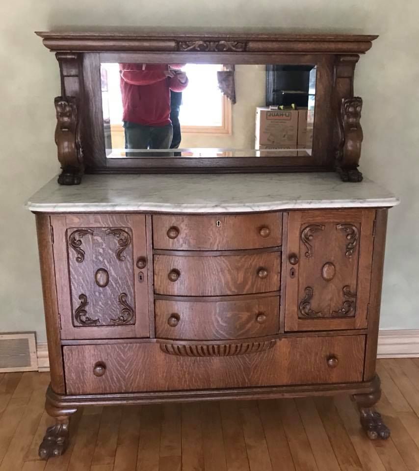 A wooden dresser with a mirror on top of it