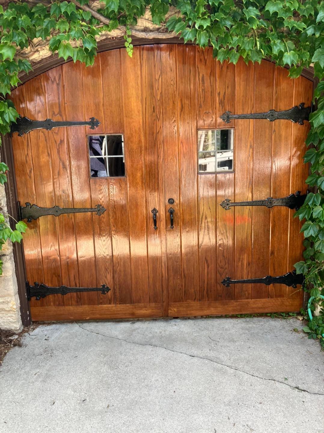 A wooden garage door with ivy growing on it.