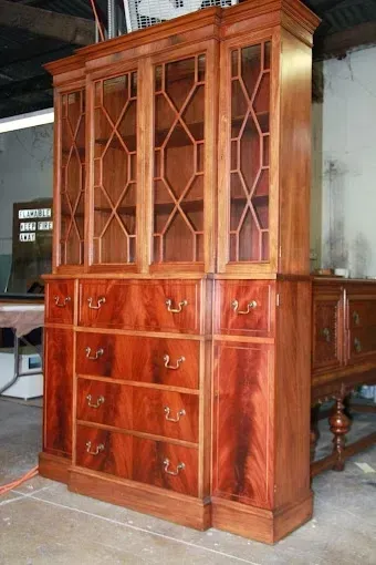A large wooden cabinet with drawers and shelves in a room.