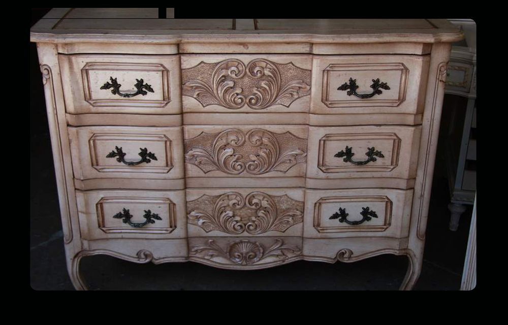 A white chest of drawers with black handles