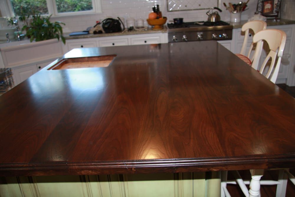 A kitchen with a large wooden table and chairs