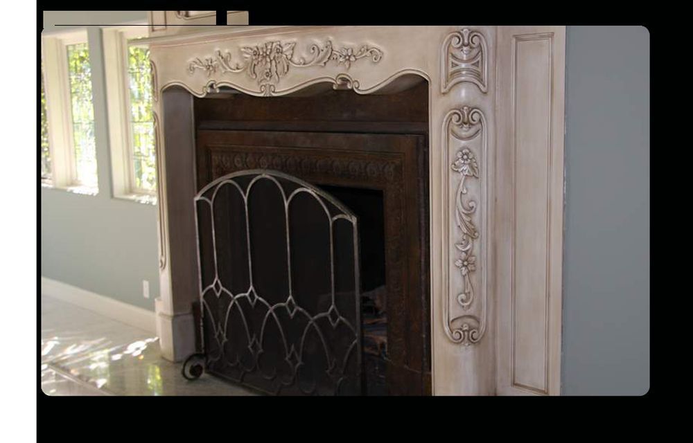 A fireplace with a black screen and a white mantle