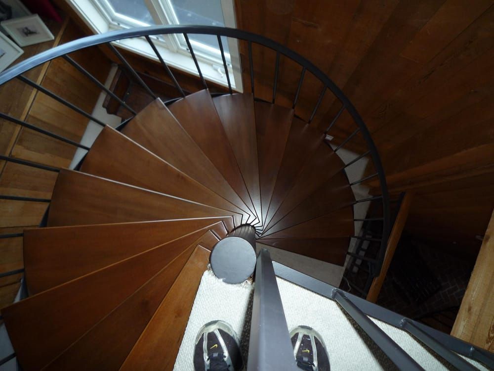 A person is standing on the bottom of a spiral staircase