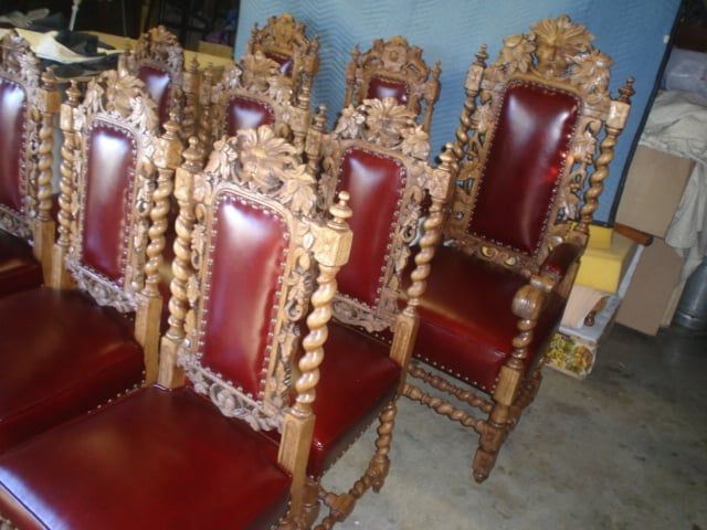 A row of wooden chairs with red leather seats