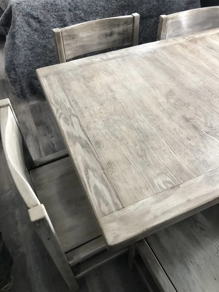 A wooden table and chairs are sitting next to each other in a living room.