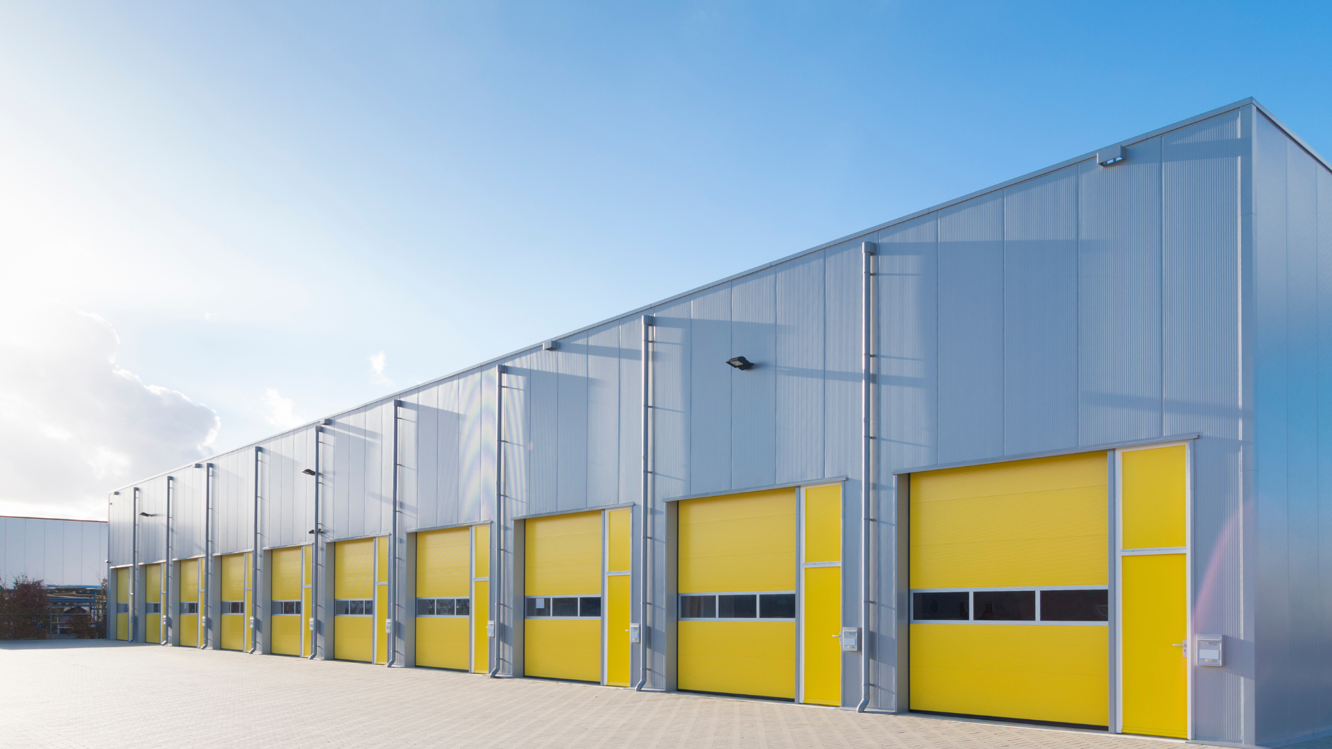 A row of yellow garage doors on the side of a building.