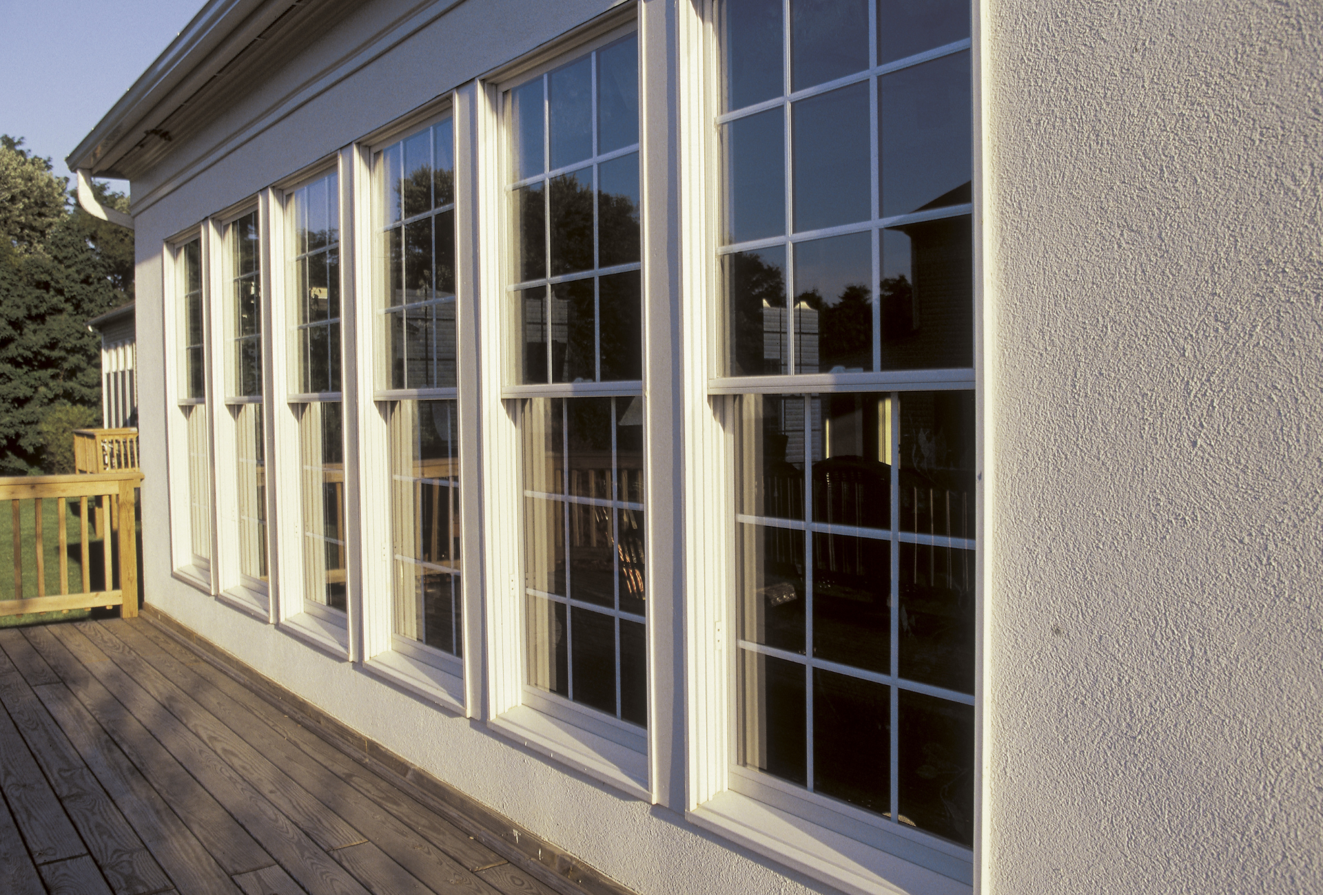A house with a lot of windows and a wooden deck