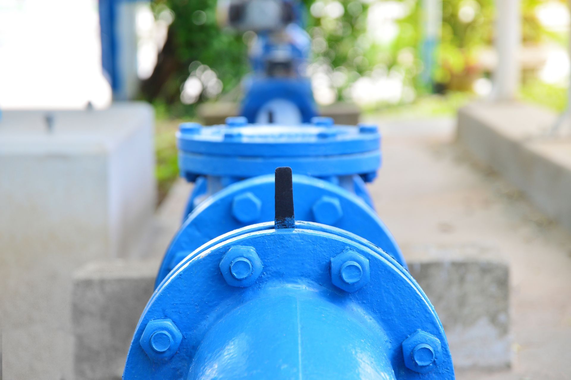 A close up of a blue pipe with nuts and bolts on it.