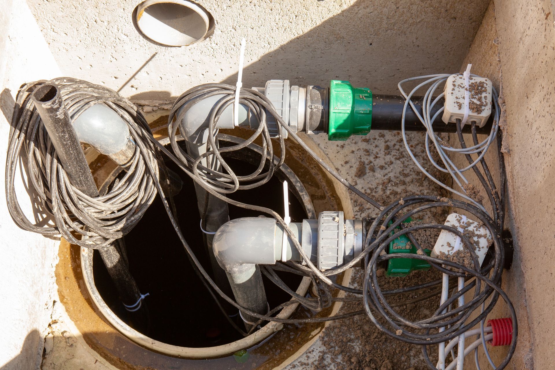 A manhole cover with a bunch of wires coming out of it.