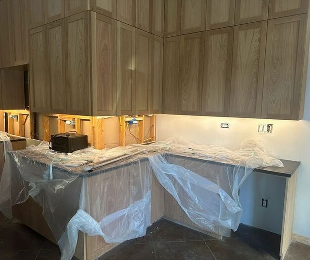 Kitchen cabinets installed above a partially covered countertop during home renovation