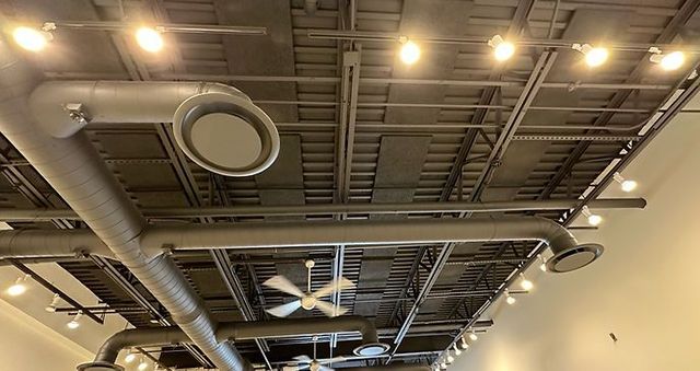 Ceiling with exposed ducts, vents, and lights in an industrial-style interior