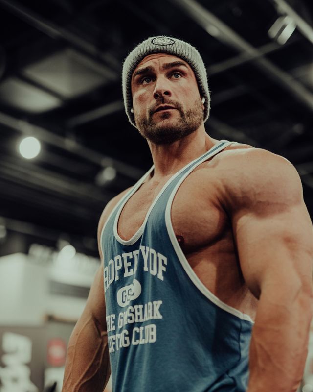 A man wearing a tank top that says ropeydf on it