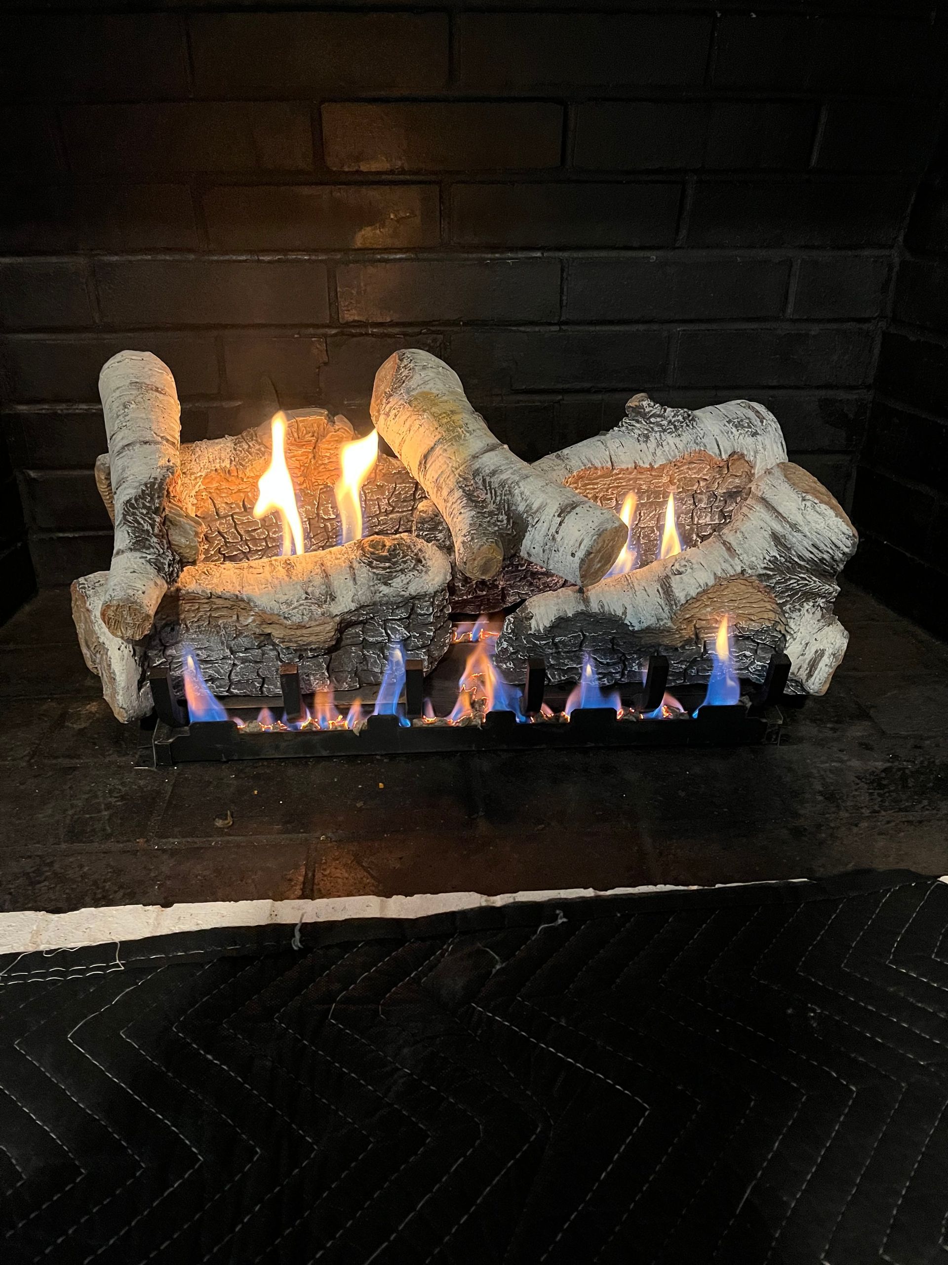 A person holding a baby up in the air indoors near a window, baby smiling.
