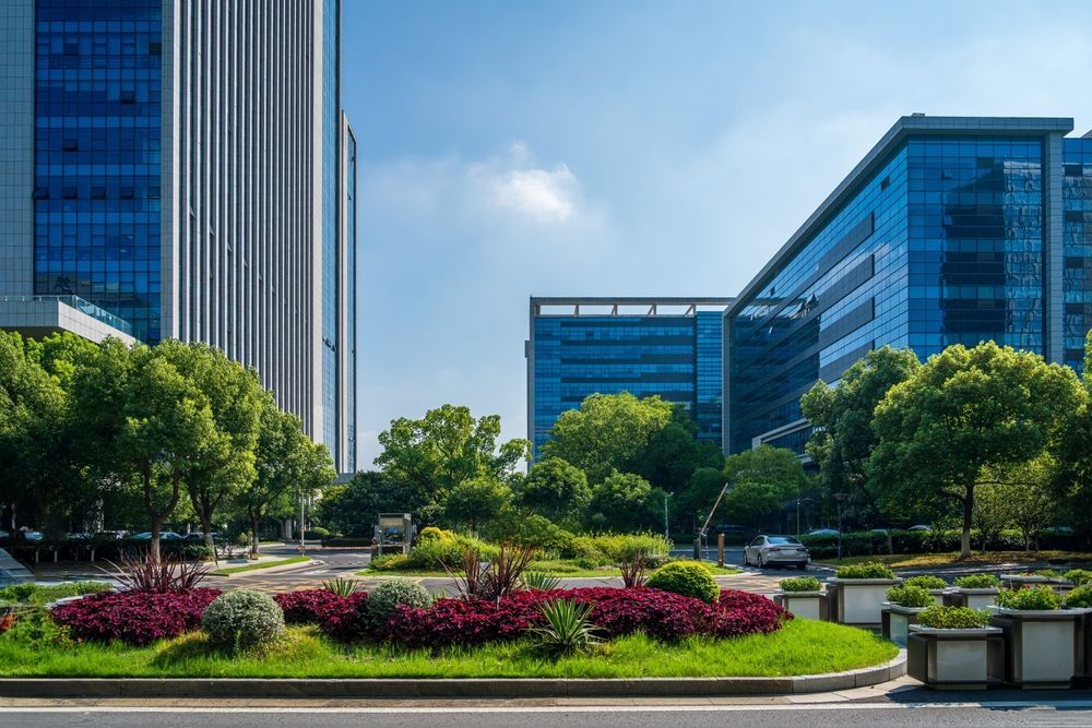 Office buildings with glass facades and landscaping under a blue sky.