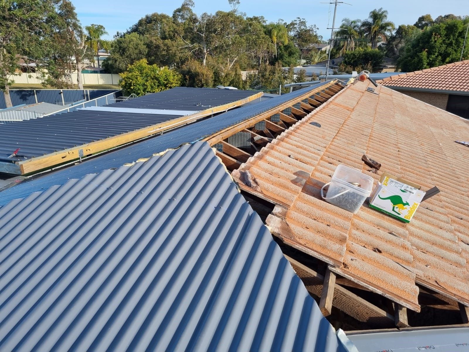The roof of a house is being repaired and the roof is missing shingles.