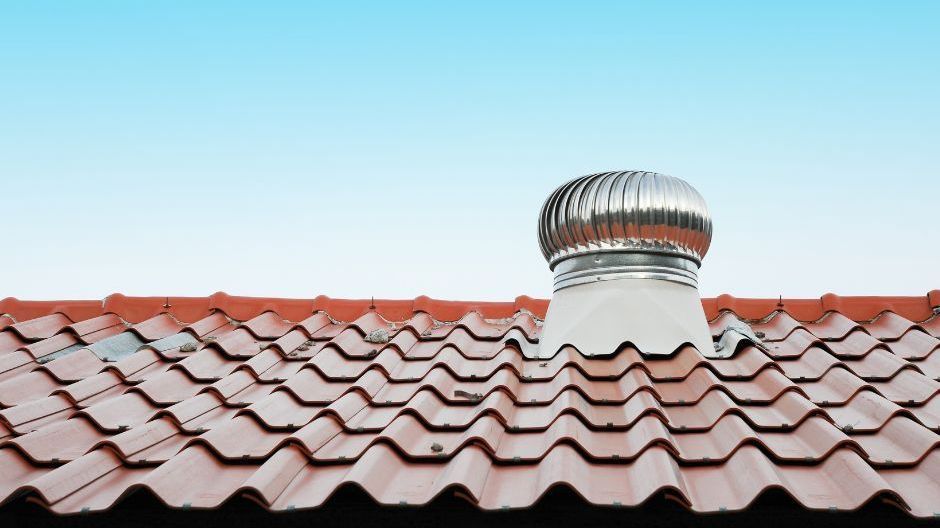 A ladder is attached to the roof of a house.