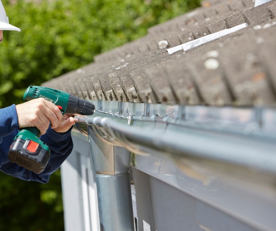 A professional roofer securing the newly installed gutter