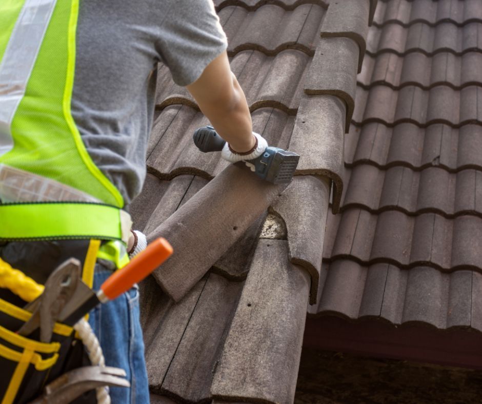 A professional roofer replacing a damaged roof tile