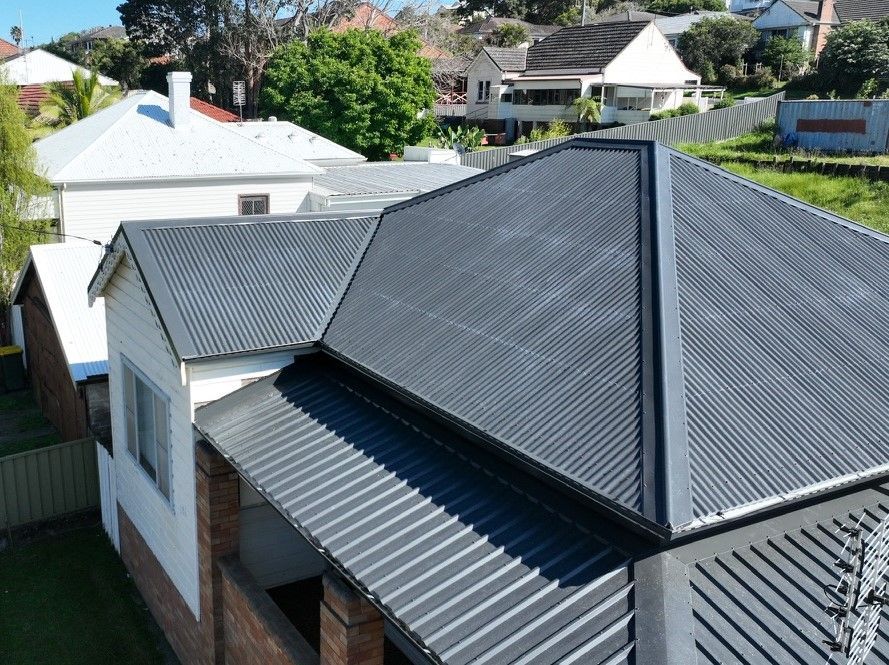 Three men are working on the roof of a house