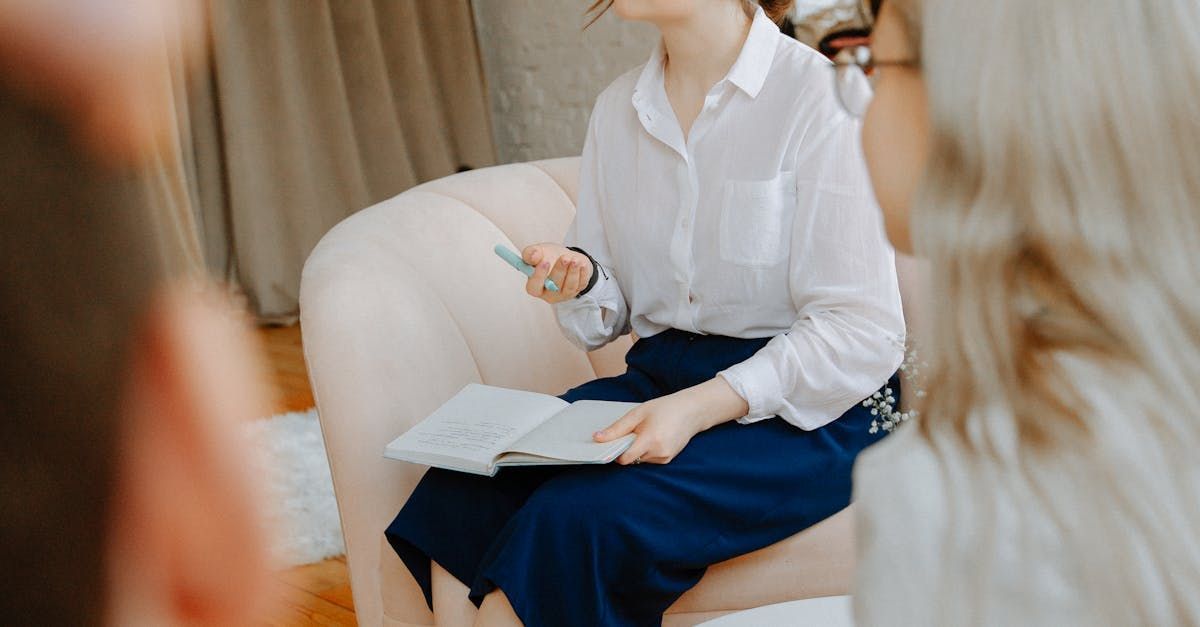 A woman is sitting in a chair holding a book.